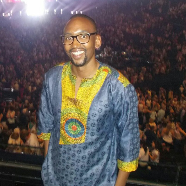 Photo of  Mokheseng R Buti smiling in front of a crowd of people.
